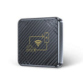 Gold and white wireless CarPlay and Android Auto USB adapter box for cars on a dark surface.