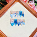 Set of blue hand-painted carved summer ice transparent plastic fake nails in XS, S, M, and L sizes.