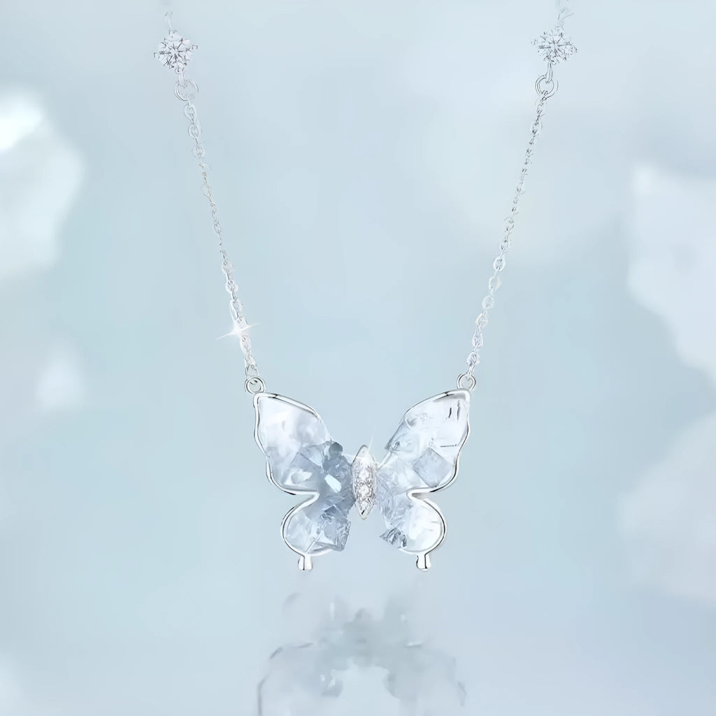 Close-up of a silver necklace with a detailed ice rain butterfly pendant on an O-ring chain.