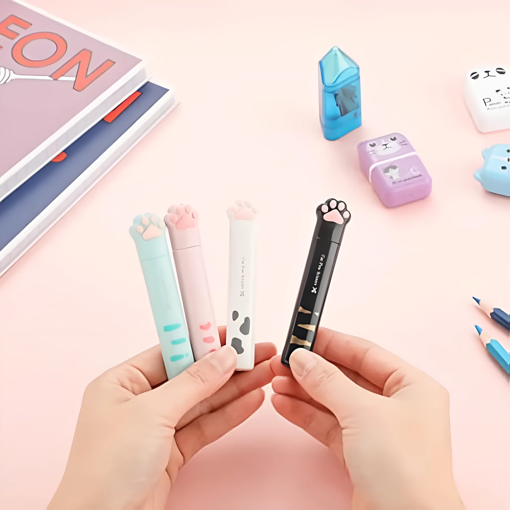 Cat paw cartoon design mini folding safety scissors in four colours: black, blue, pink, and white.