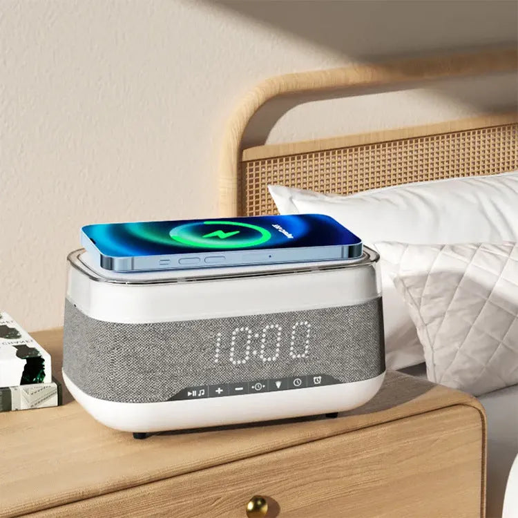 White multifunctional alarm clock with Bluetooth speaker and wireless charging pad on a bedside table.