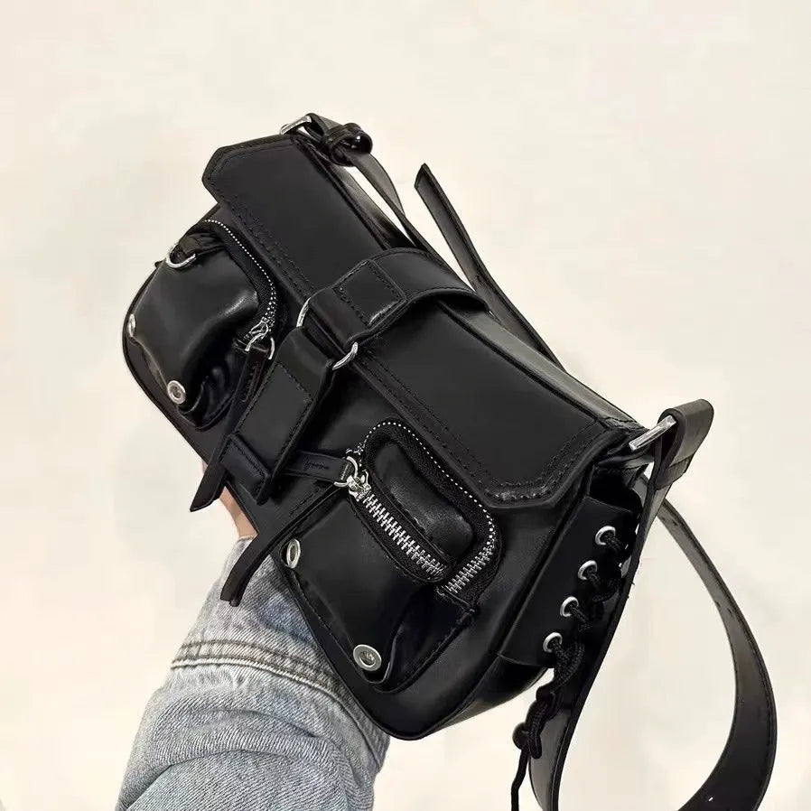 Black women's underarm baguette messenger bag with single shoulder strap showing interior zipper pocket