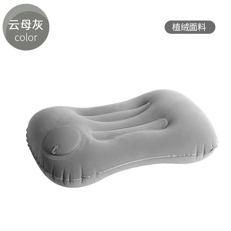 Grey inflatable travel pillow with soft flocking surface, shown deflated and inflated.