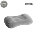 Grey inflatable travel pillow with soft flocking surface, shown deflated and inflated.