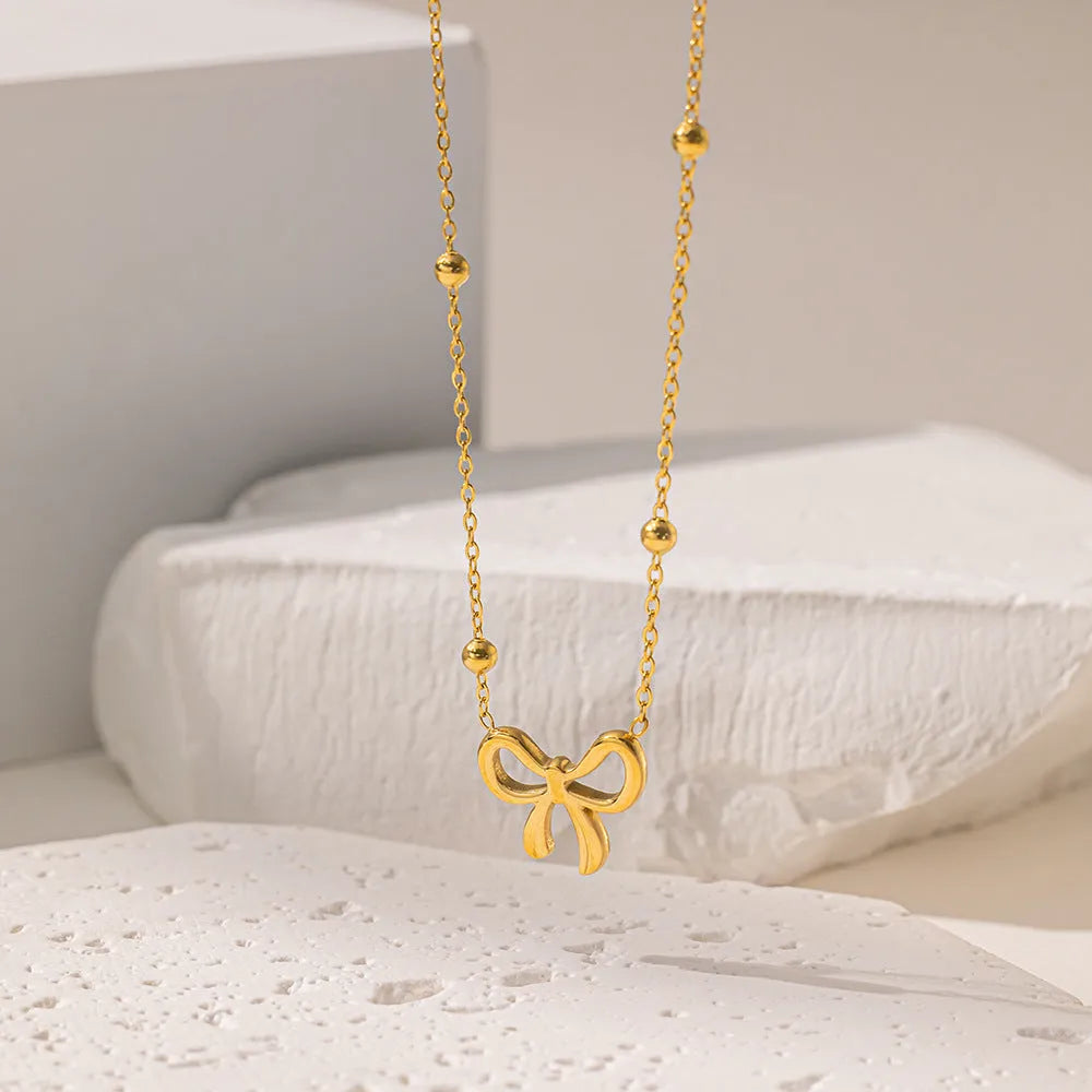 Gold electroplated bow necklace with cross chain design on adjustable 41-50cm chain