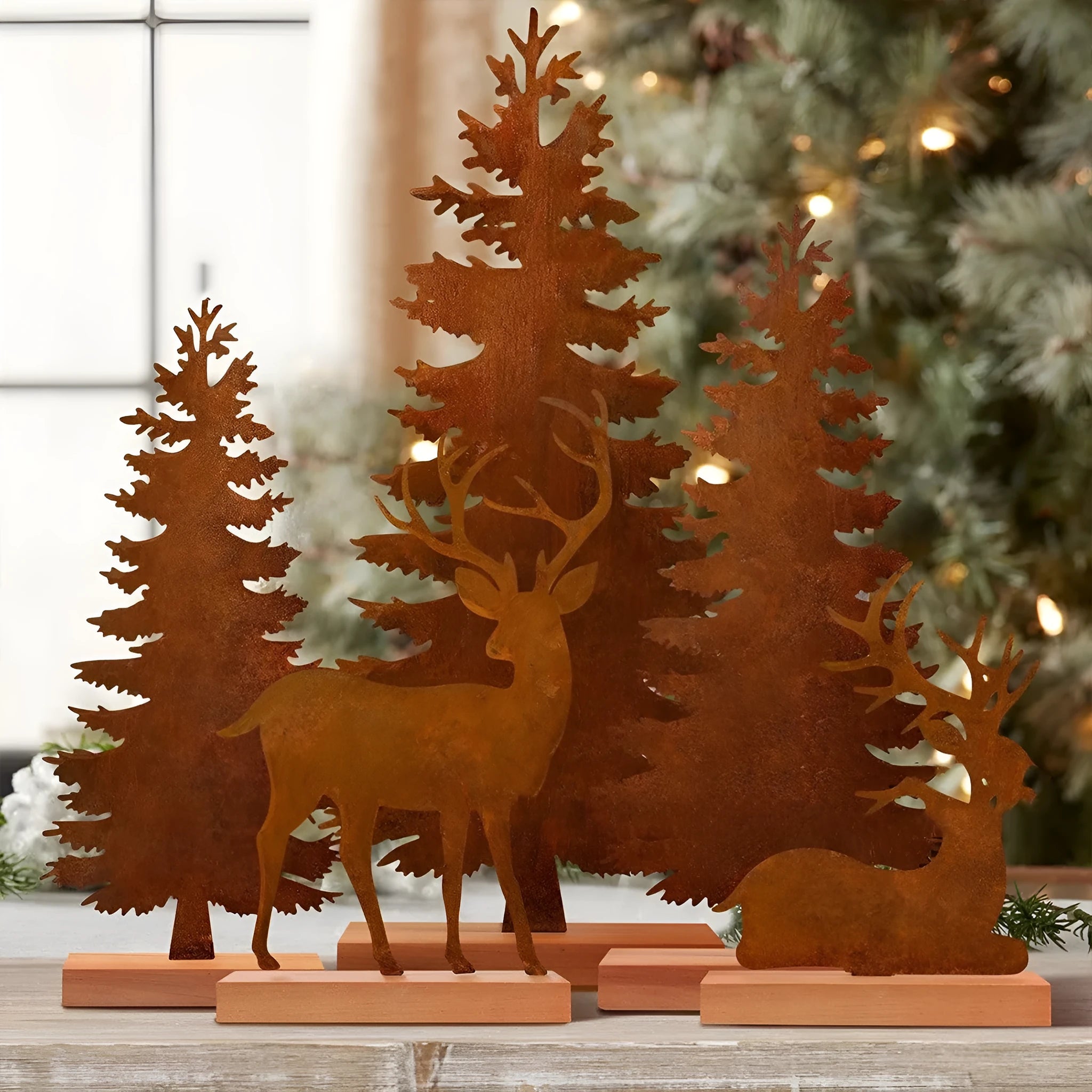 Set of three rusty metal Christmas ornaments featuring elk with antlers and trees, on a white background