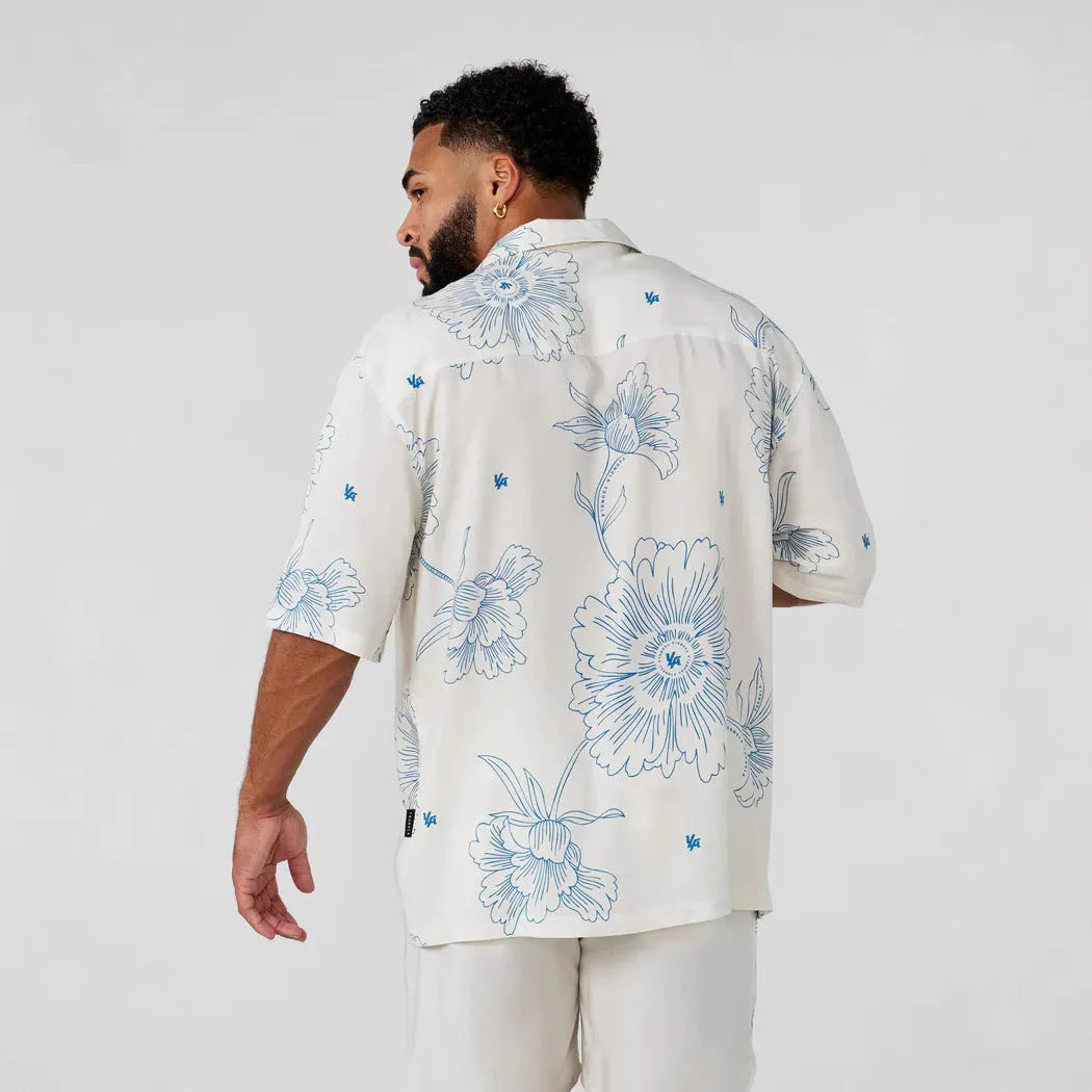 Man's loose-fitting short sleeve cardigan top with a floral print in light colours.