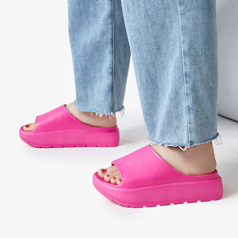 Women's beige fish mouth style EVA slippers with a thick sole, shown on a sandy beach background.