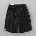 Men's loose fit linen shorts in green on a neutral background