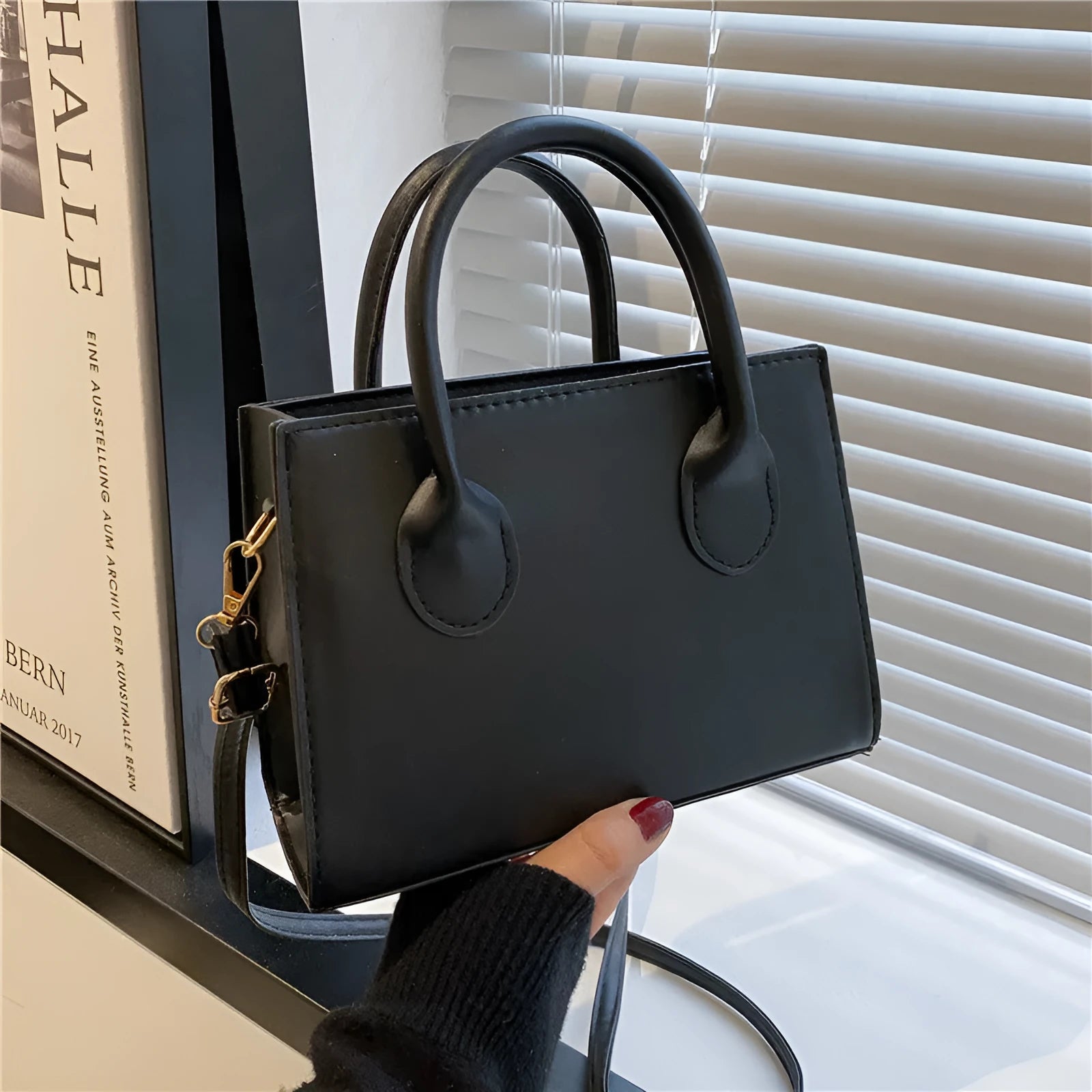 Women's black PU leather horizontal square shoulder bag with single strap and sewing line detailing