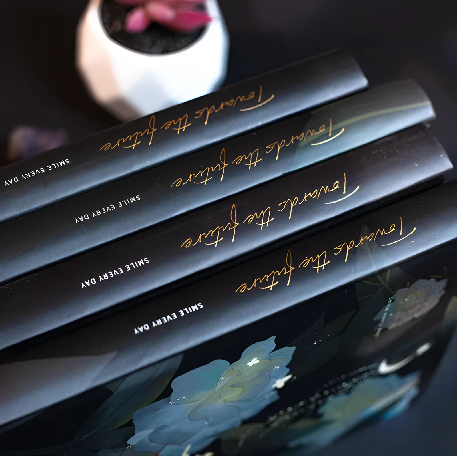A5 notebook with luminous cover and silver foiling, open to show pages with colour illustrations.