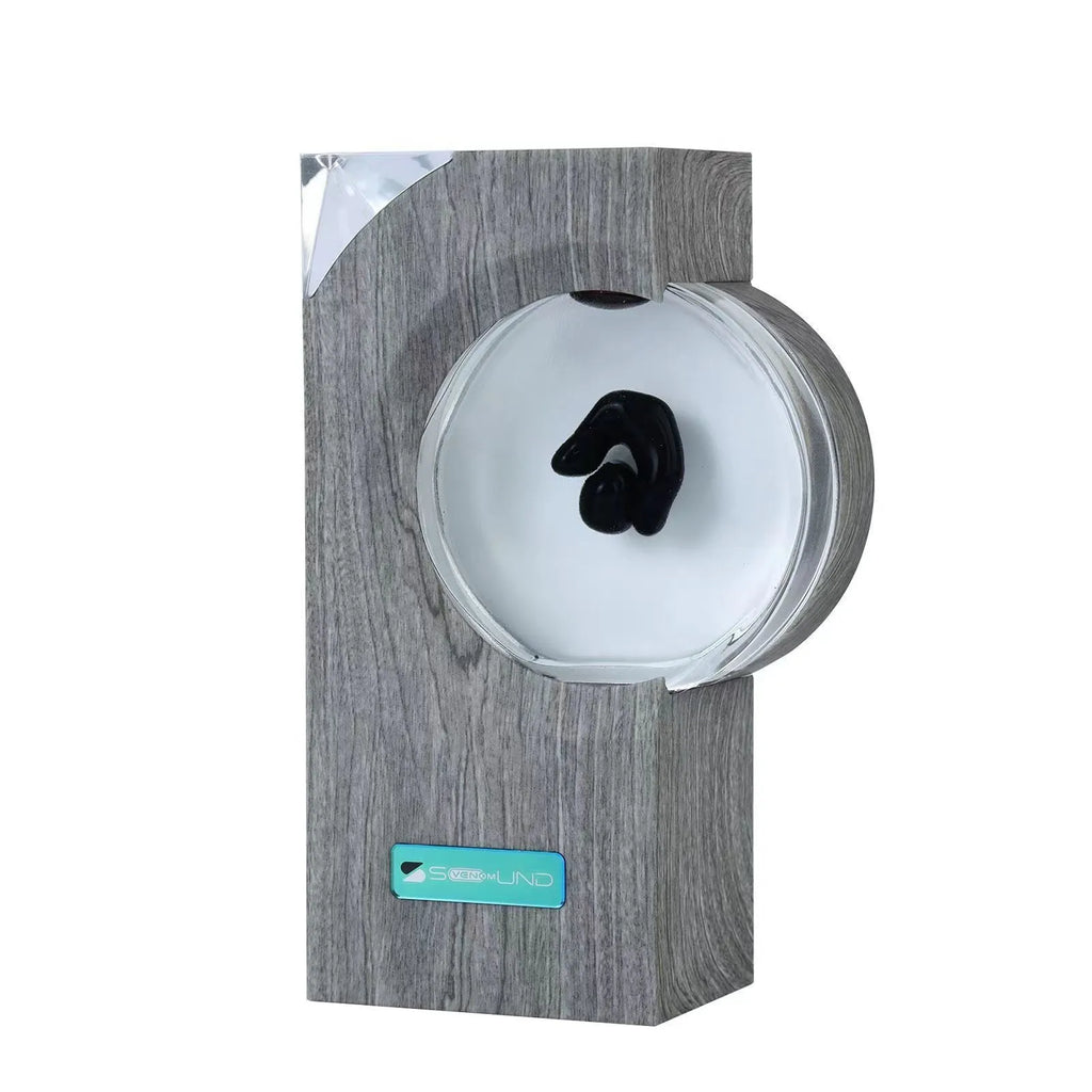 Dancing ferrofluid speaker in gray plastic casing with warm white light showing magnetic fluid shapes