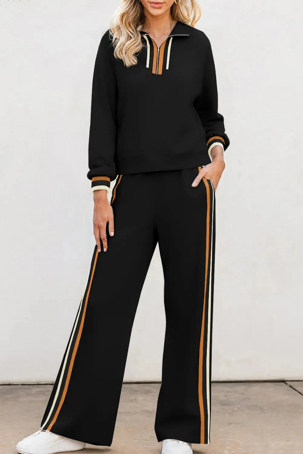 Black striped patchwork quarter zip pullover and loose pant set on a model, showing loose fit and striped detailing.