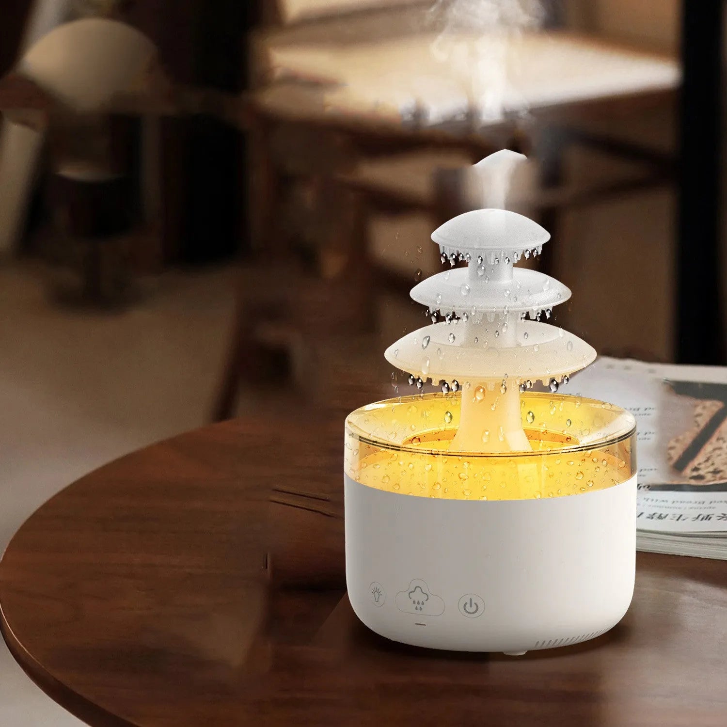 White cloud rain shape ultrasonic humidifier and essential oil diffuser with colourful LED lights on a table.