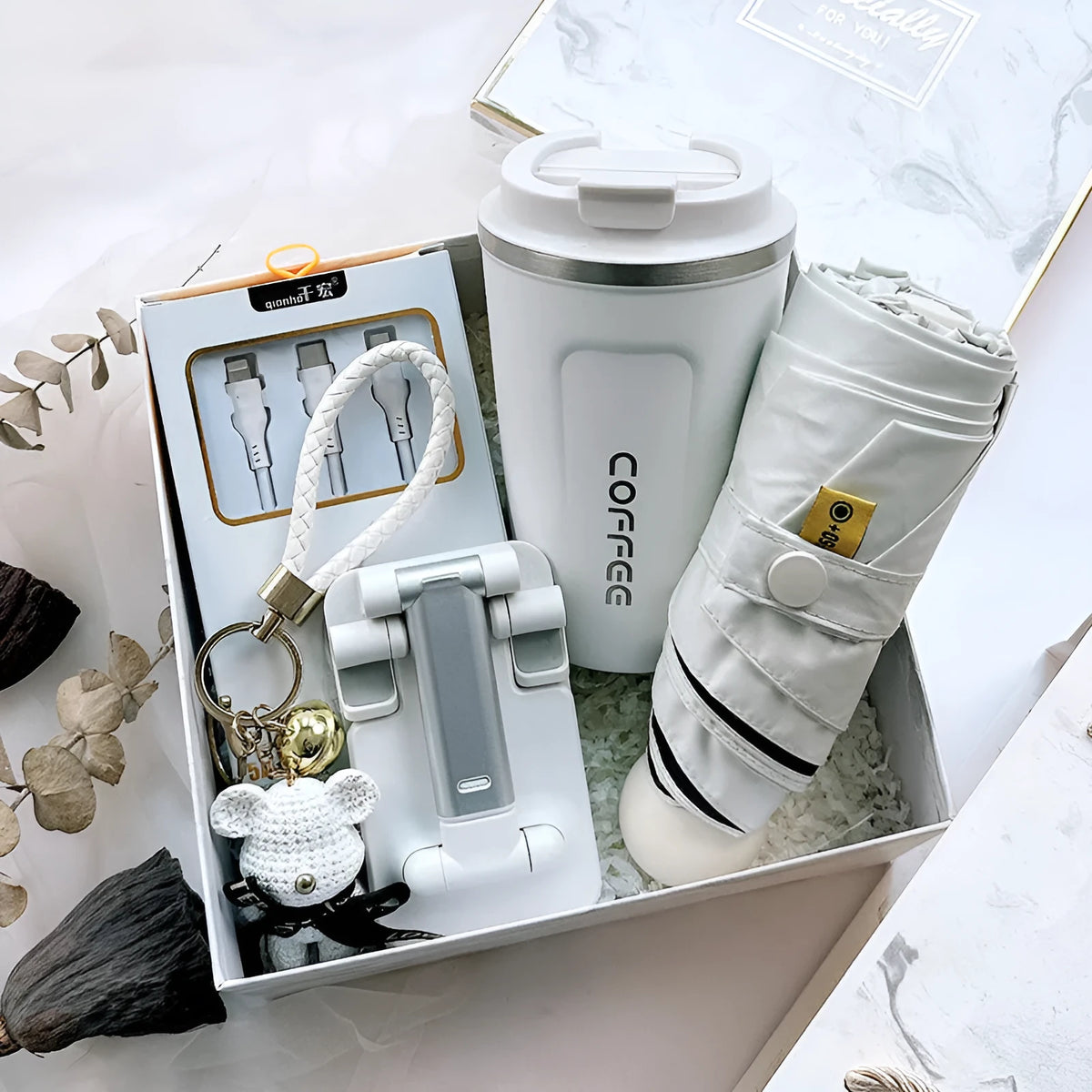Metal business gift set with bracket, keychain, umbrella, cup, and data cable on a neutral background