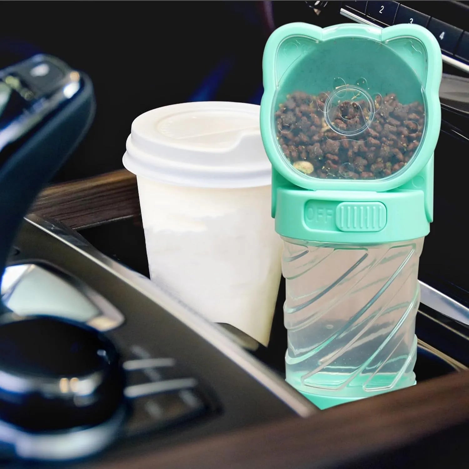 Green 3-in-1 portable pet water bottle with food container and bag dispenser, held by its strap.