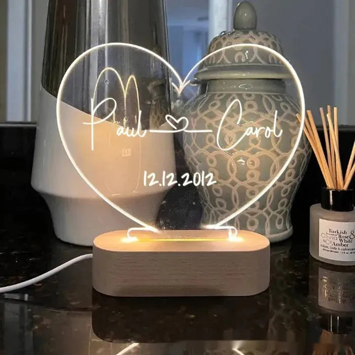 Custom acrylic night light with engraved names and date, lit by LED base.