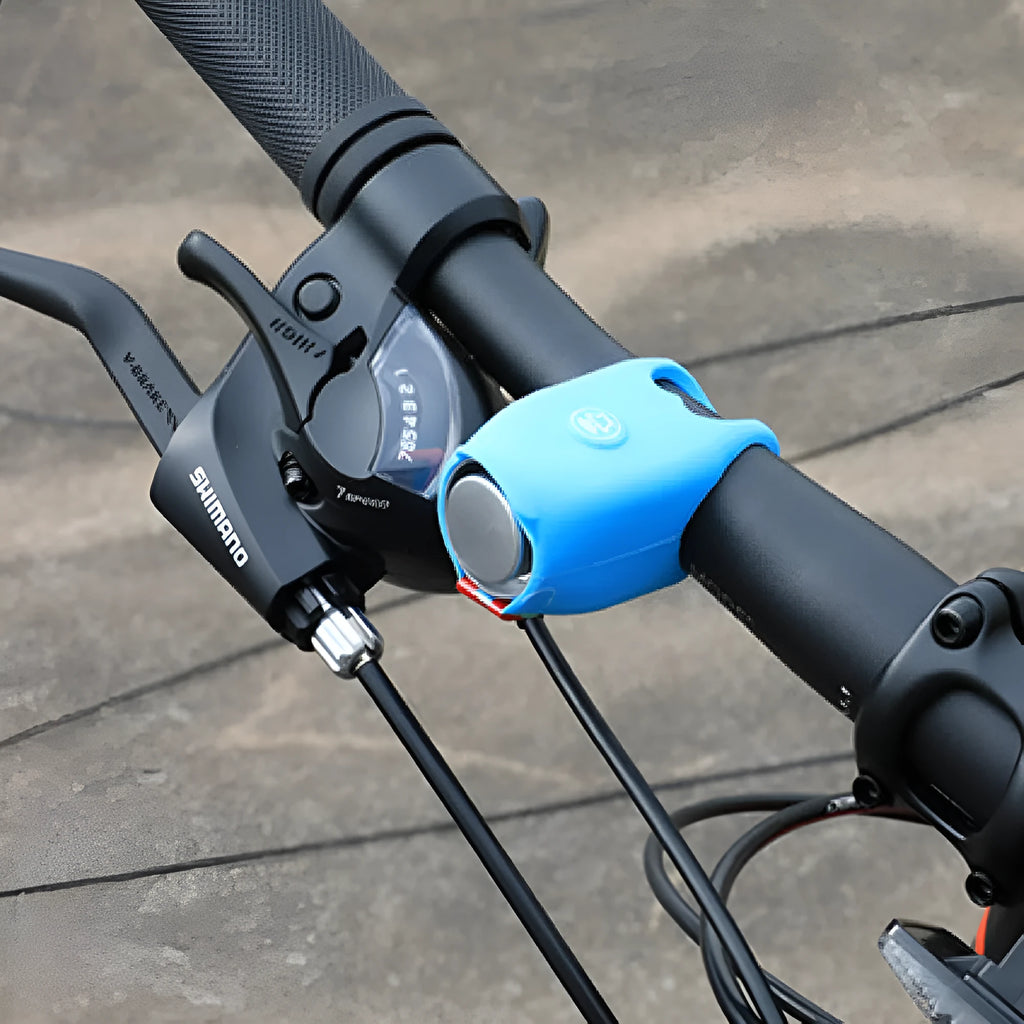 Black electronic bicycle horn with button, mounted on a bicycle handlebar.
