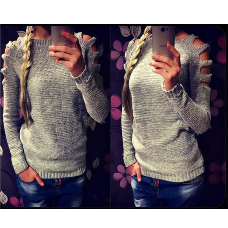 White women's hollow-out knitted long sleeve shirt with round neck on a hanger.