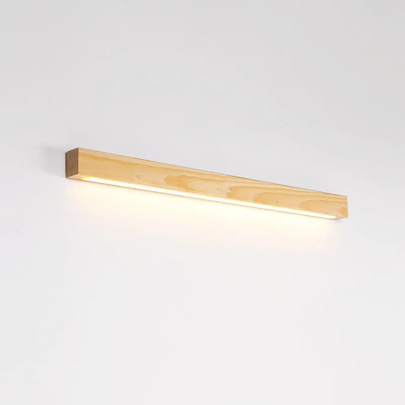 Slim, long walnut-coloured wooden strip wall lamp mounted on a plain wall.