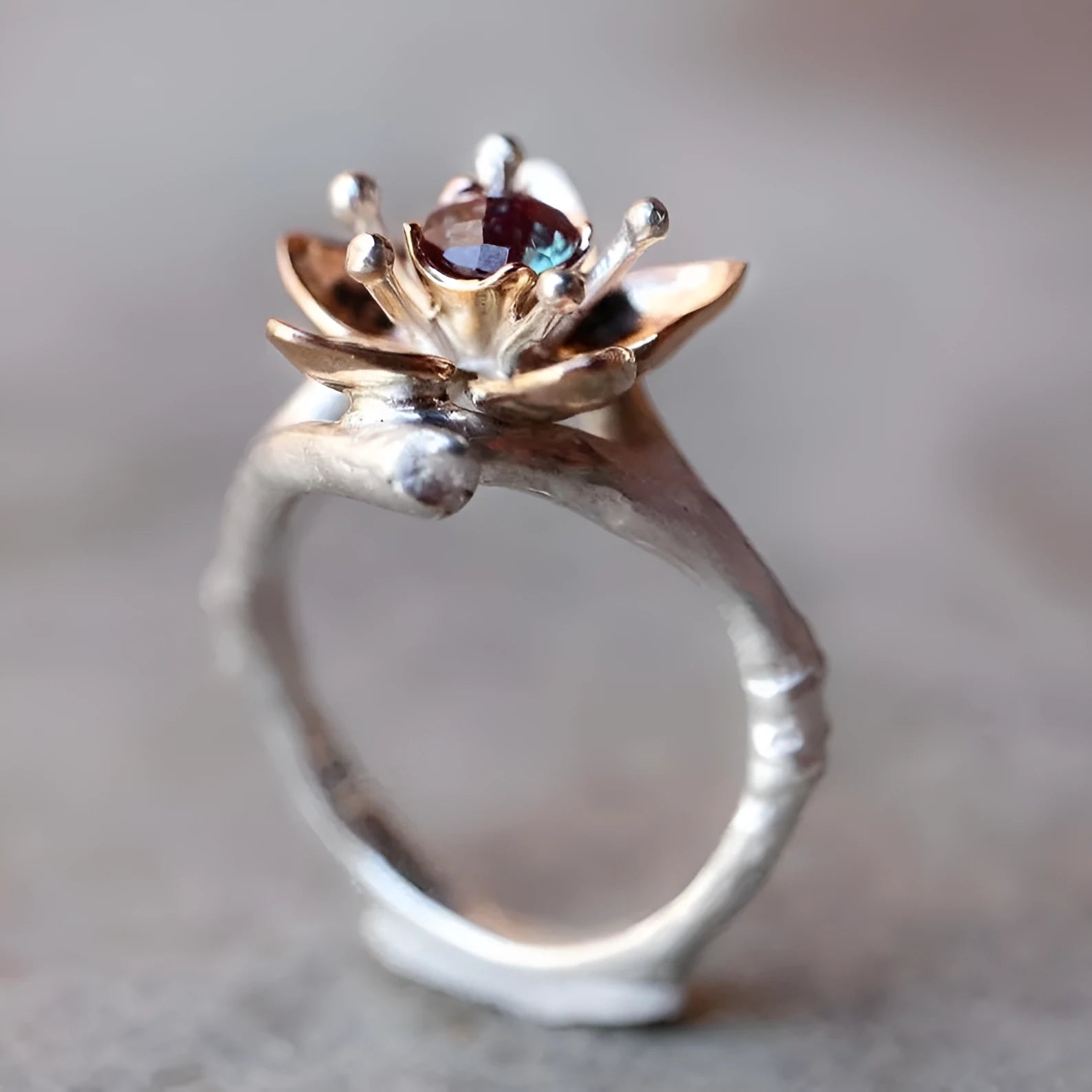 A two-tone silver women's ring with a geometric band and a floral ornament.