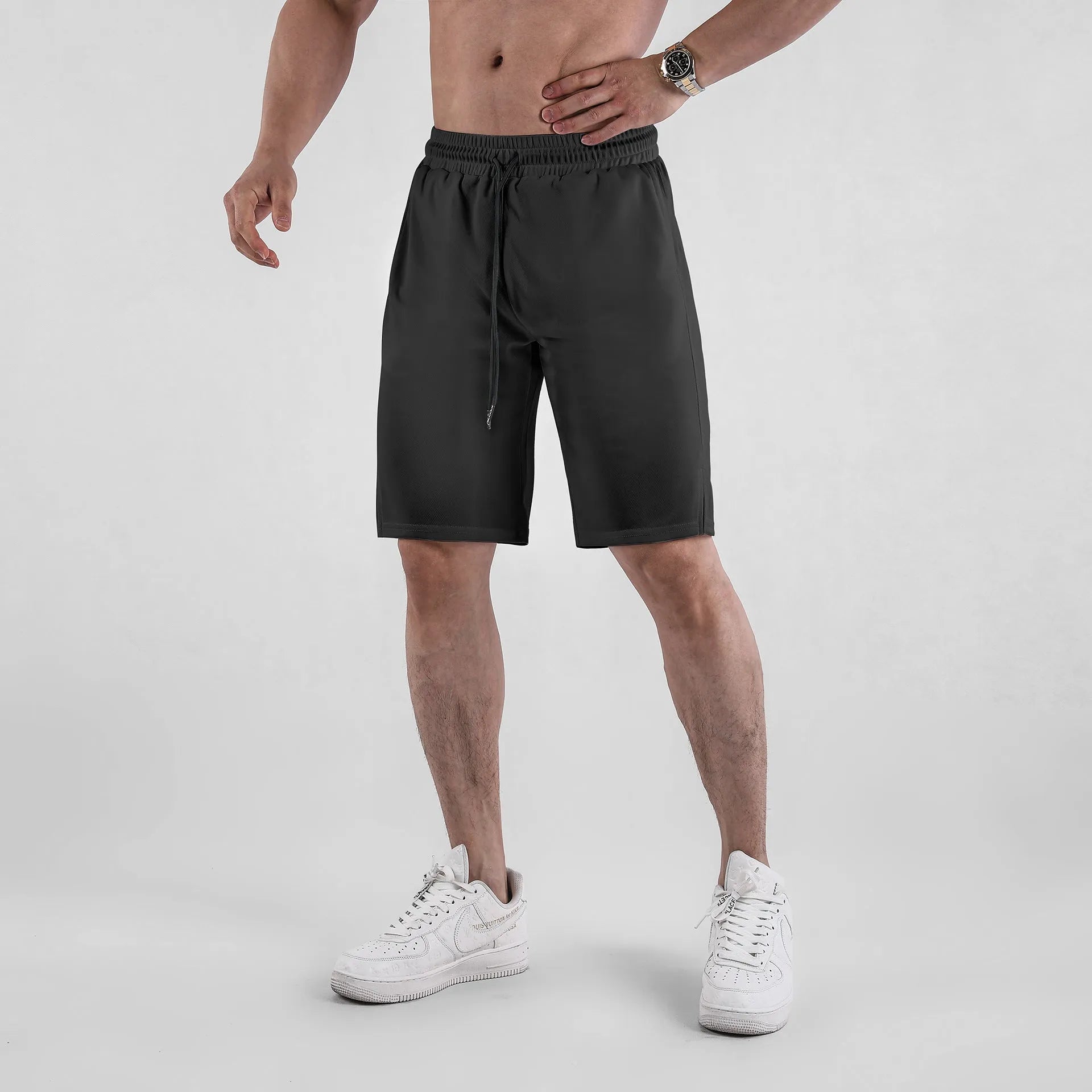 Men's black quick-dry mesh sports shorts with an elastic waistband on a white background.