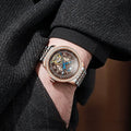 Men's stainless steel mechanical watch with a round dial, butterfly buckle, and transparent case back.