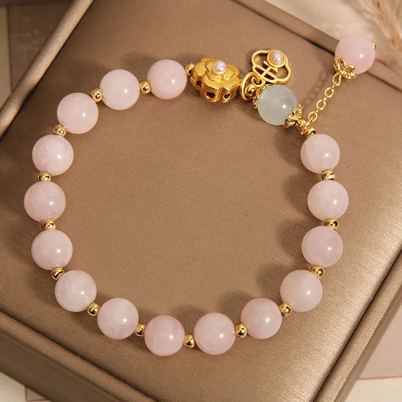 Women's pink crystal flower bracelet with clear crystal stones forming floral design pattern.