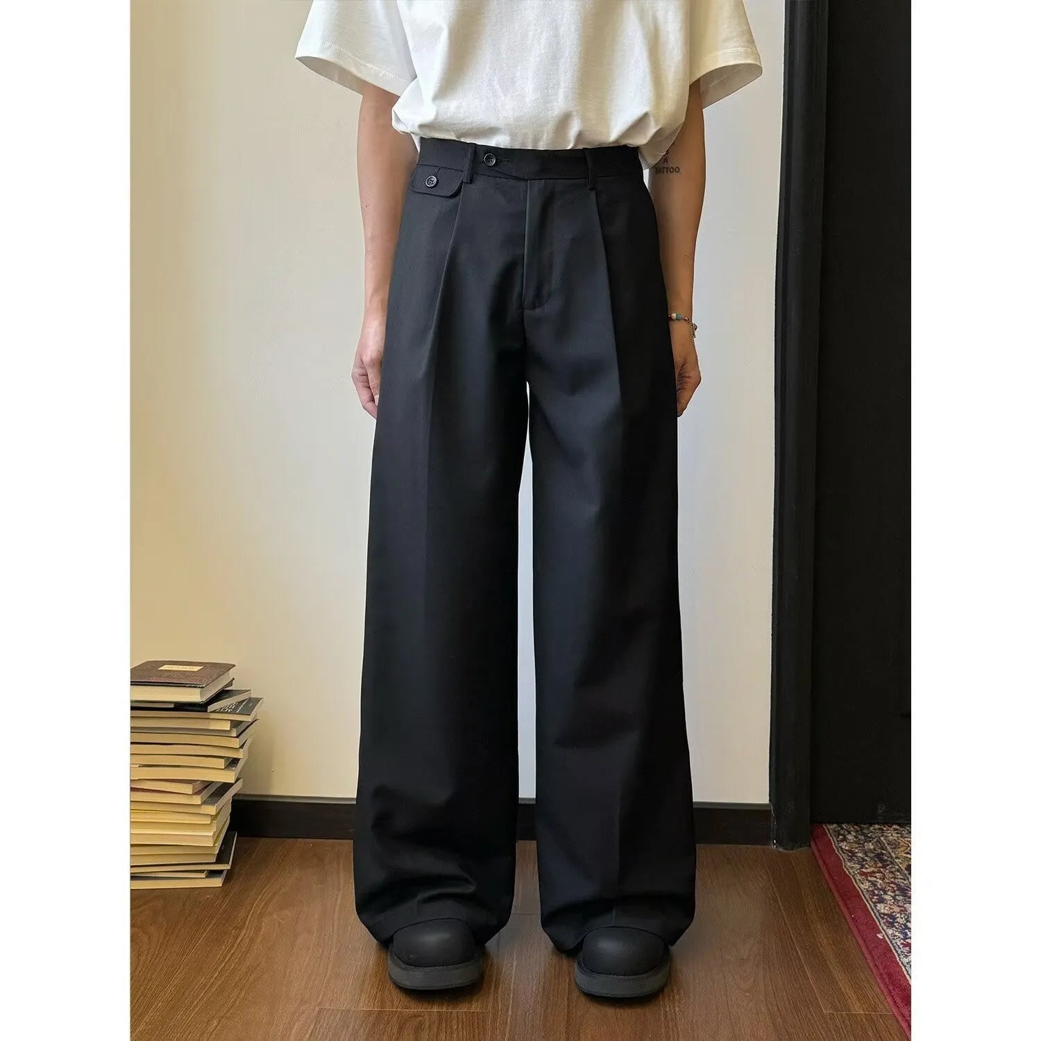 Men's straight-leg wide-leg casual trousers in black, showing loose fit and draping fabric.