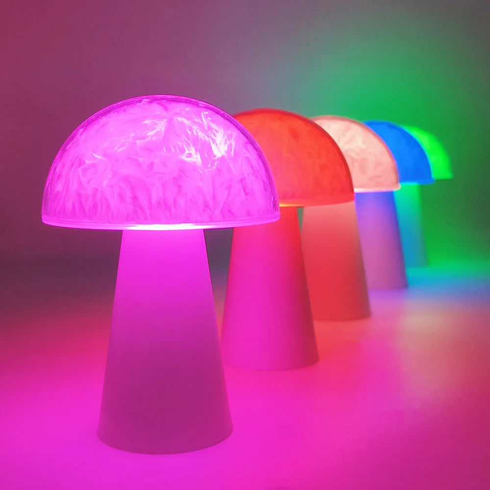 White mushroom-shaped night light with remote control on a wooden surface, showing soft RGB glow.
