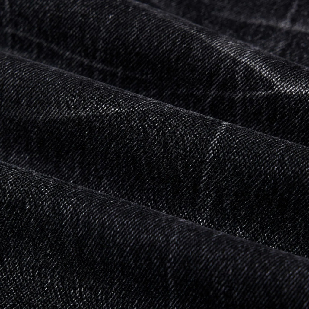 Black straight-leg jeans with lightning crack distressing pattern on knees and thighs