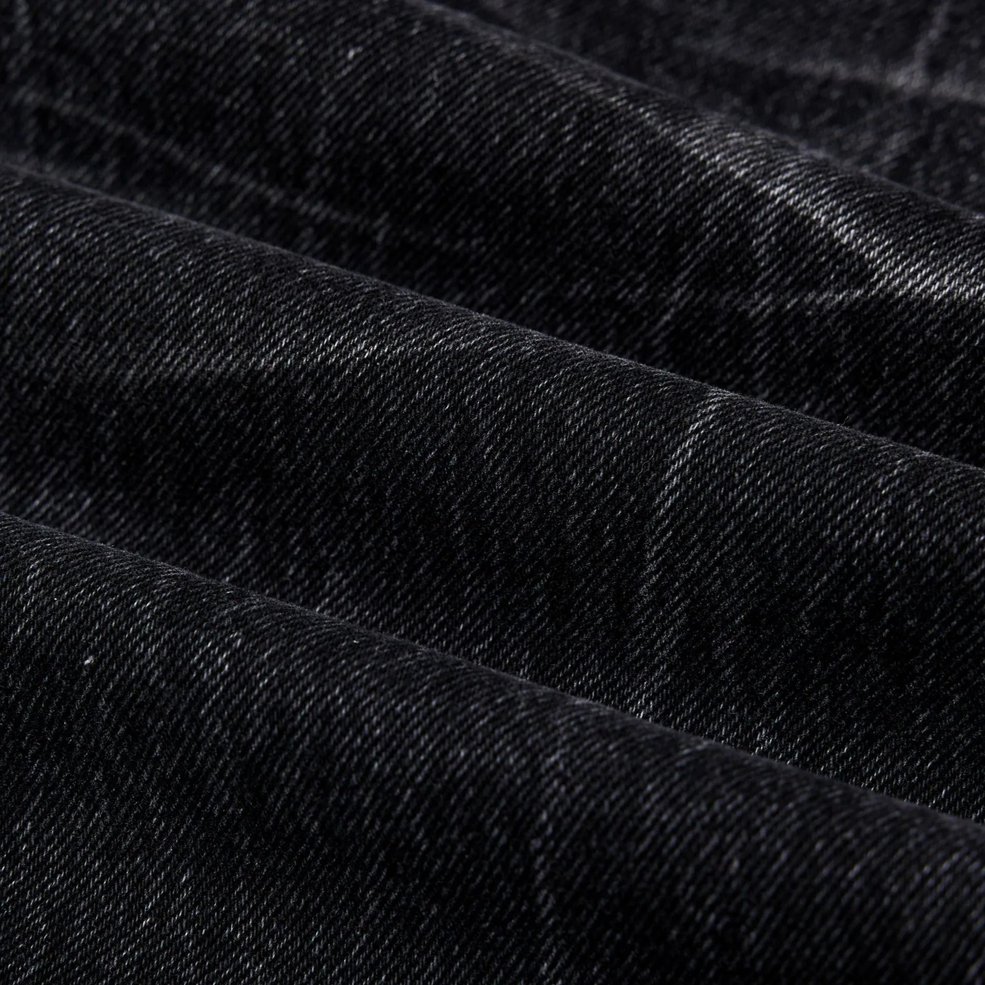 Black straight-leg jeans with lightning crack distressing pattern on knees and thighs
