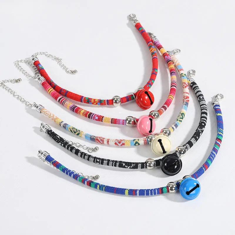 Coloured ethnic pattern adjustable pet collar with metal bell and D-ring on a nylon strap.