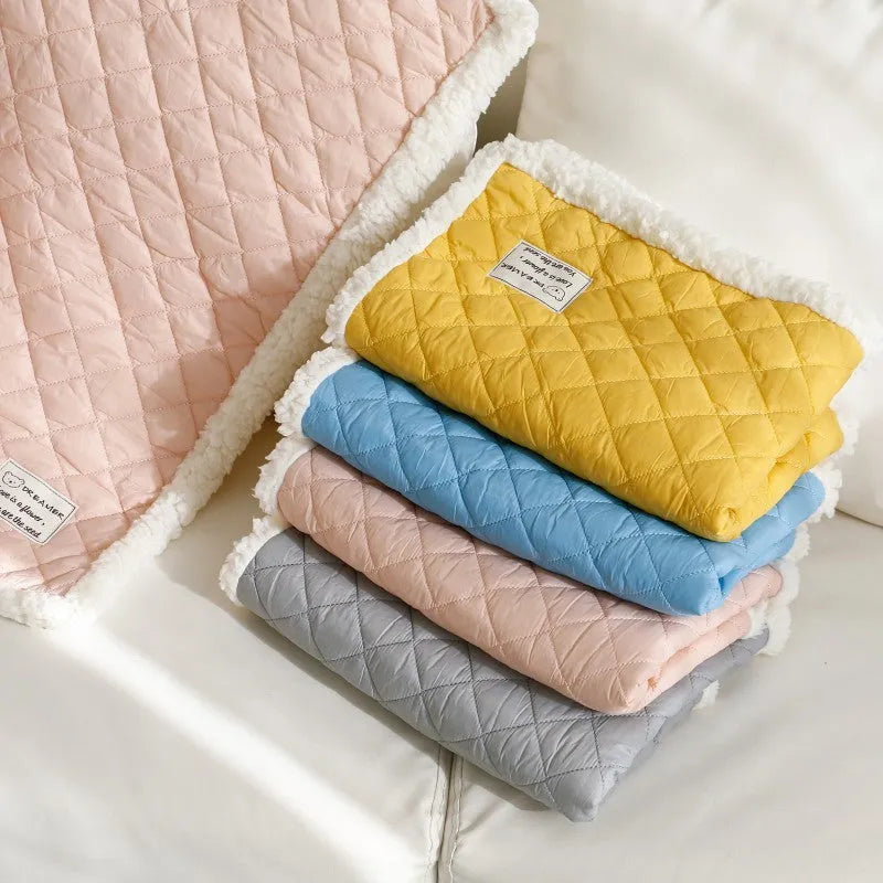 Blue quilted terry cloth pet blanket for cats showing textured surface and size scale.