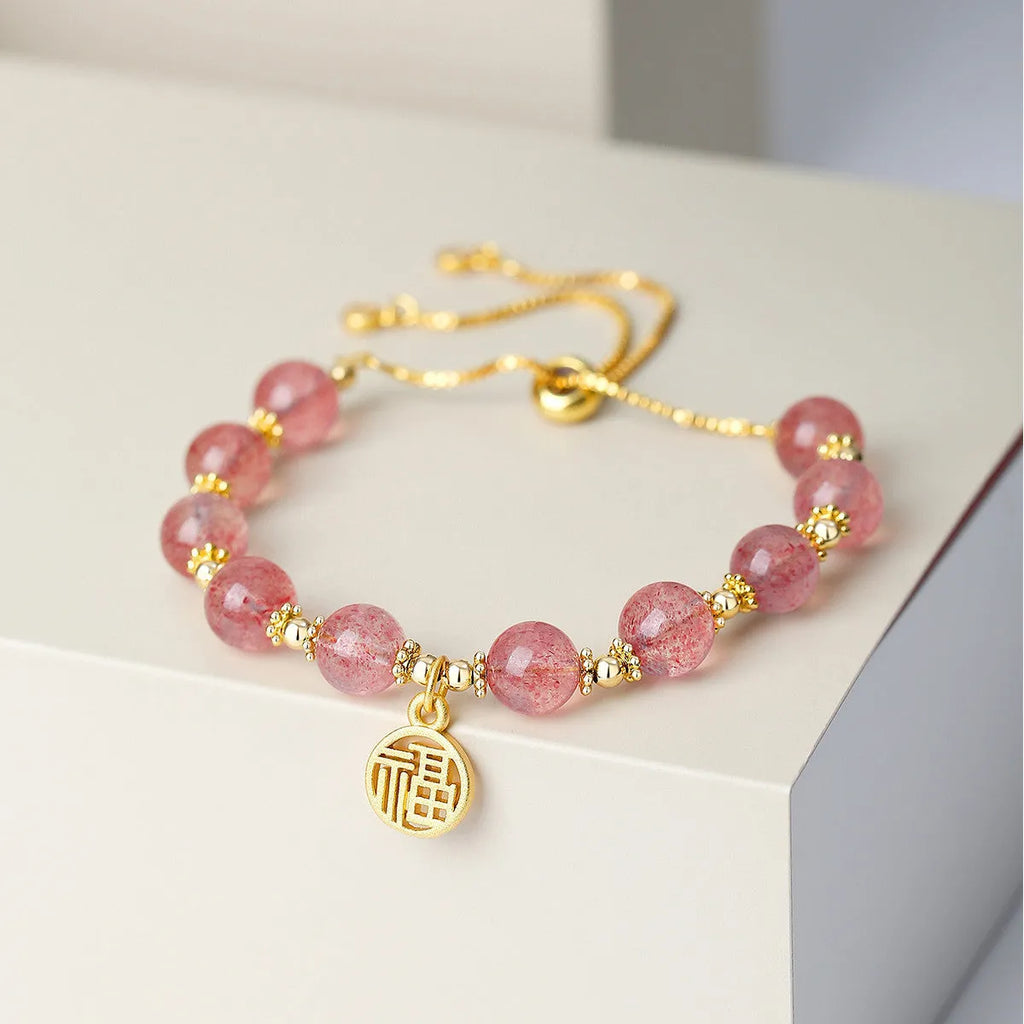 Women's strawberry quartz crystal bracelet with electroplated fu character charm and geometric design