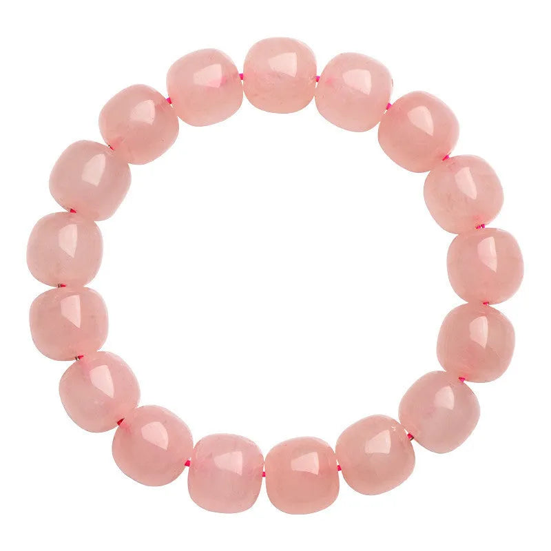 Close-up of a pink natural crystal barrel bead bracelet with geometric beads on a wrist.