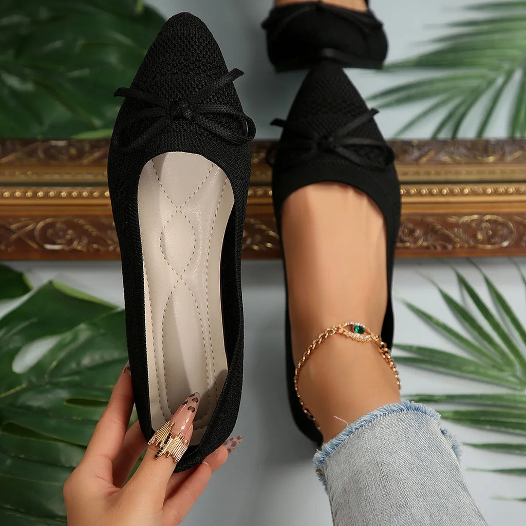 Women's blue knitted flat loafers with a bow and pointed toe on a rubber sole.