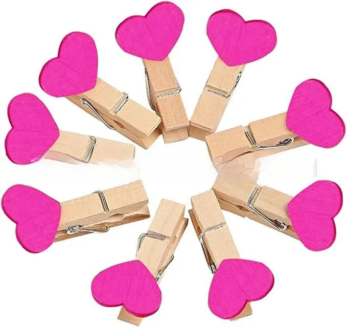 Five small wooden heart-shaped clips in red, pink, yellow, white, and rose red colours on a neutral background.