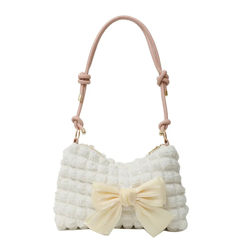 Street style canvas one-shoulder handbag in horizontal square shape with visible stitching.