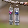 Antique finish metal stud earrings with a red sapphire in an ellipse shape, retro style.