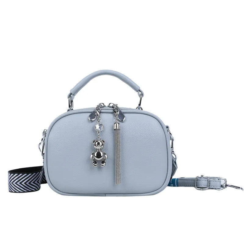 Oval-shaped women's small square shoulder bag in PU with double straps, shown in blue.