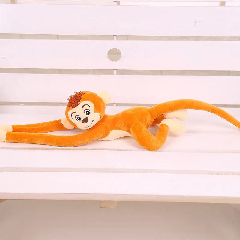 Long-arm pink plush monkey toy hanging from a curtain as home decoration.