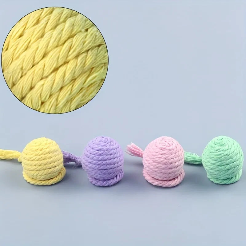 Colourful cat toy ball with attached rope and internal bell, shown in green, pink, purple, and yellow variants.