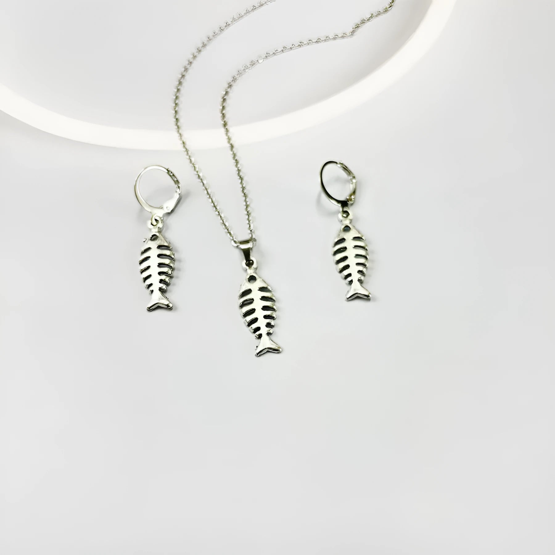 A pair of retro-style alloy earrings with a fishbone pendant hanging from an O-shaped chain.