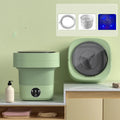 Green foldable portable mini washing machine for socks and underwear with drain pipe and basket.