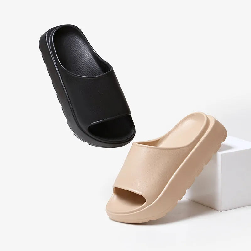 Women's beige fish mouth style EVA slippers with a thick sole, shown on a sandy beach background.