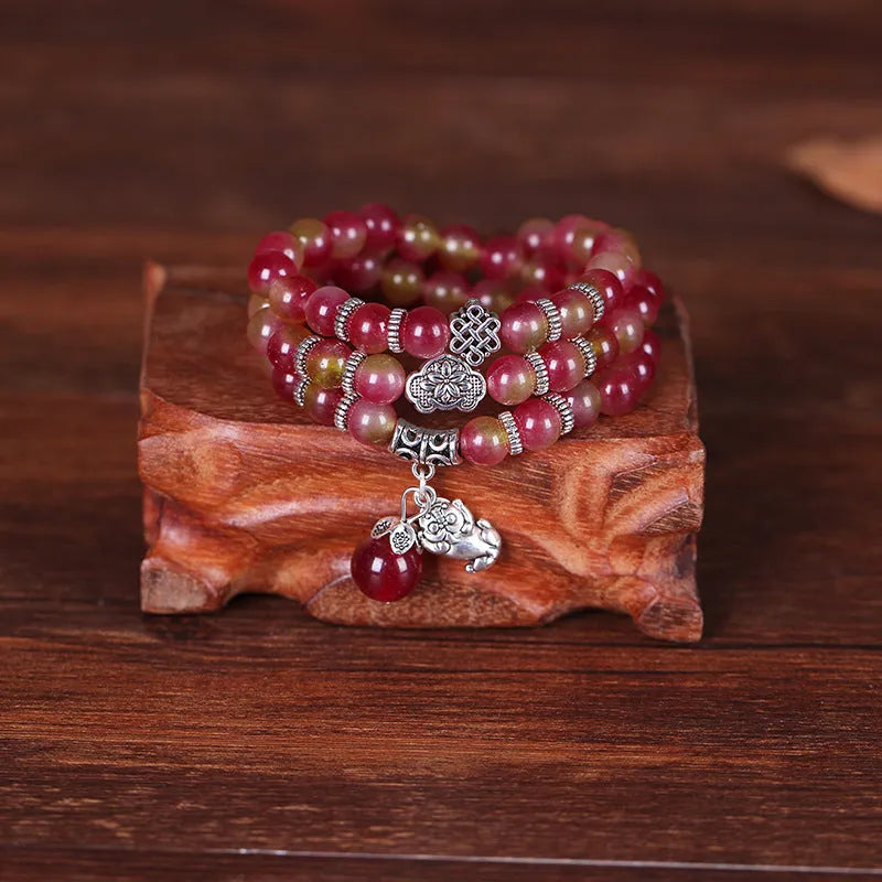 Natural watermelon crystal bracelet with Chinese knot design showing elephant style beads