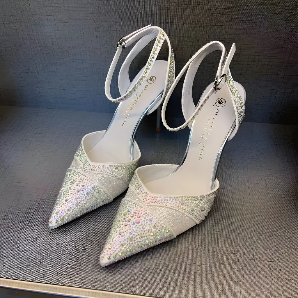 A pair of women's black hollow high heels with a red sole, stiletto heel, and pointed toe.