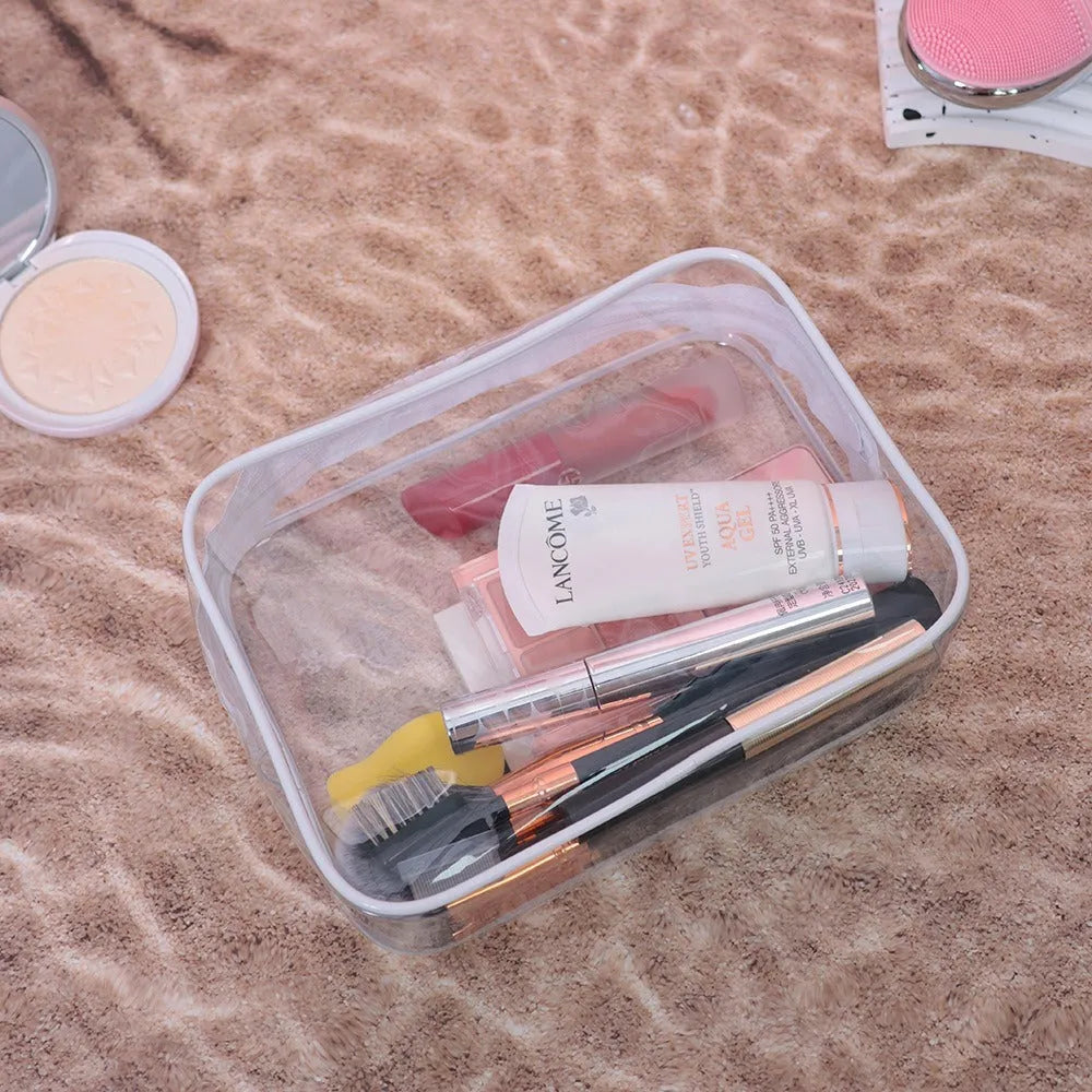 Set of three semi-transparent PVC makeup bags in black, pink, and white colours with handles
