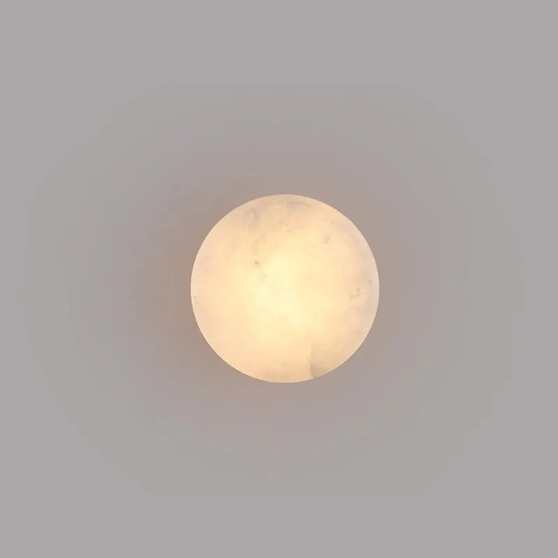 Spanish natural marble round wall lamp with warm light, 130mm diameter, black finish on a bedroom wall